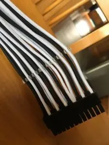 Black and white braided sleeved cables gathered into a 24-pin motherboard connector