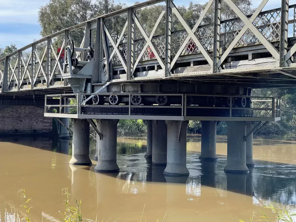 The swing span from the side, its rollers riding a circular rack above concrete piers
